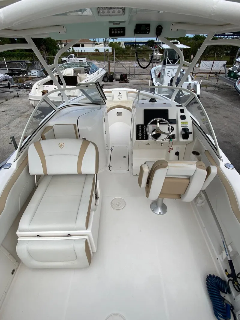 Slide: The Image of 2017 Century 24 Resorter boat interior with white and beige seating, steering console, and open deck. - 4