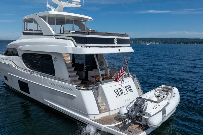 Slide: The Image of Luxury 2017 Ocean Alexander 70 E yacht on open water, featuring sleek design and tender boat. - 10