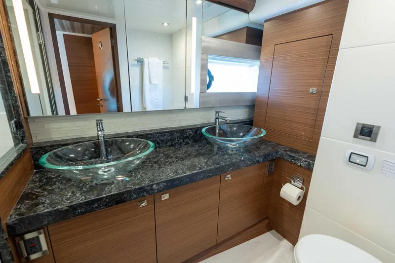 Slide: The Image of Luxurious bathroom in 2017 Ocean Alexander 70 E yacht with dual glass sinks and wood cabinetry. - 26