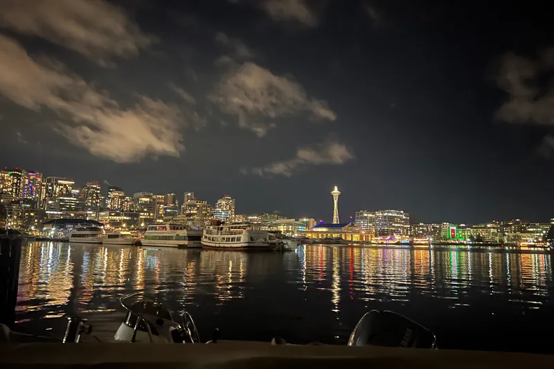 Slide: The Image of Seattle skyline at night with boats and Space Needle reflection on water. - 59