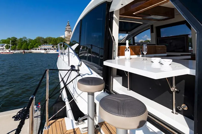 Slide: The Image of 2024 Galeon 470 Sky yacht interior with dining setup and ocean view. - 7