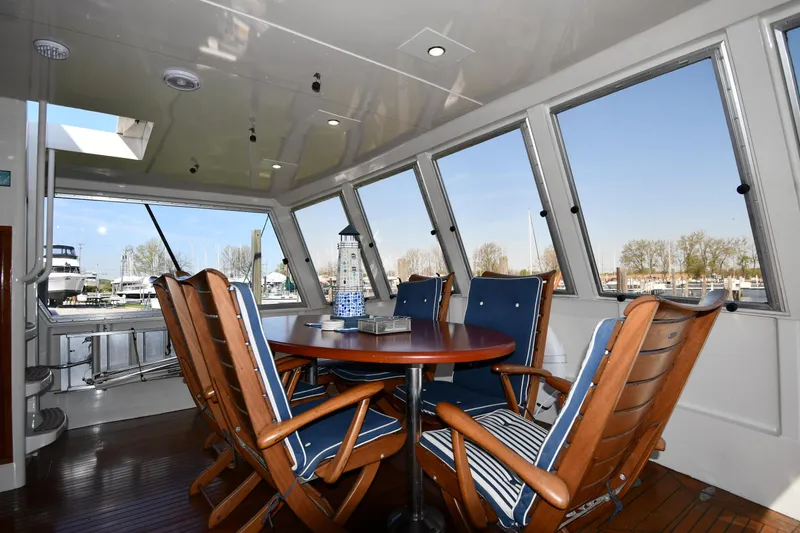 Slide: The Image of 1986 Lowland 64 Pilot House Long Range Motor Yacht interior with dining area and panoramic windows. - 23