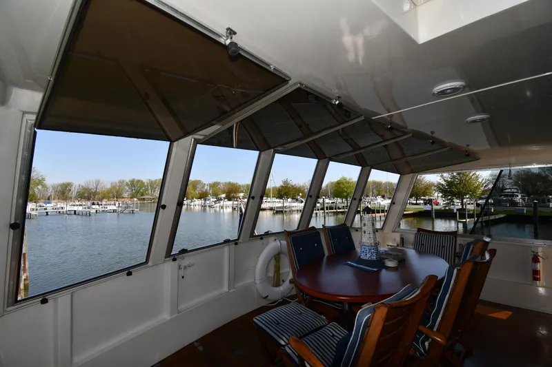 Slide: The Image of Enclosed deck area of 1986 Lowland 64 Pilot House Long Range Motor Yacht with marina view. - 25
