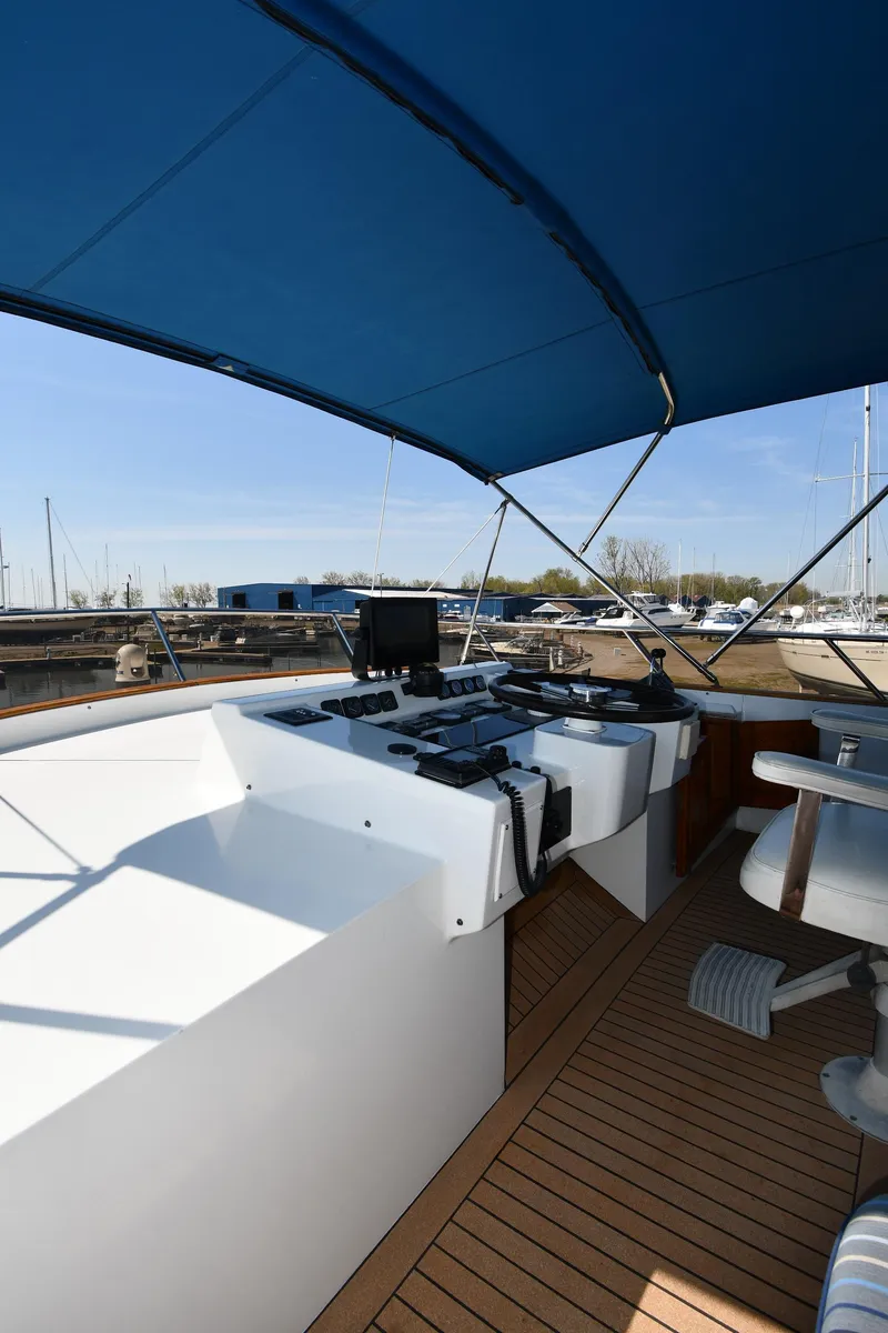 Slide: The Image of 1986 Lowland 64 Pilot House Long Range Motor Yacht helm station with blue canopy. - 30