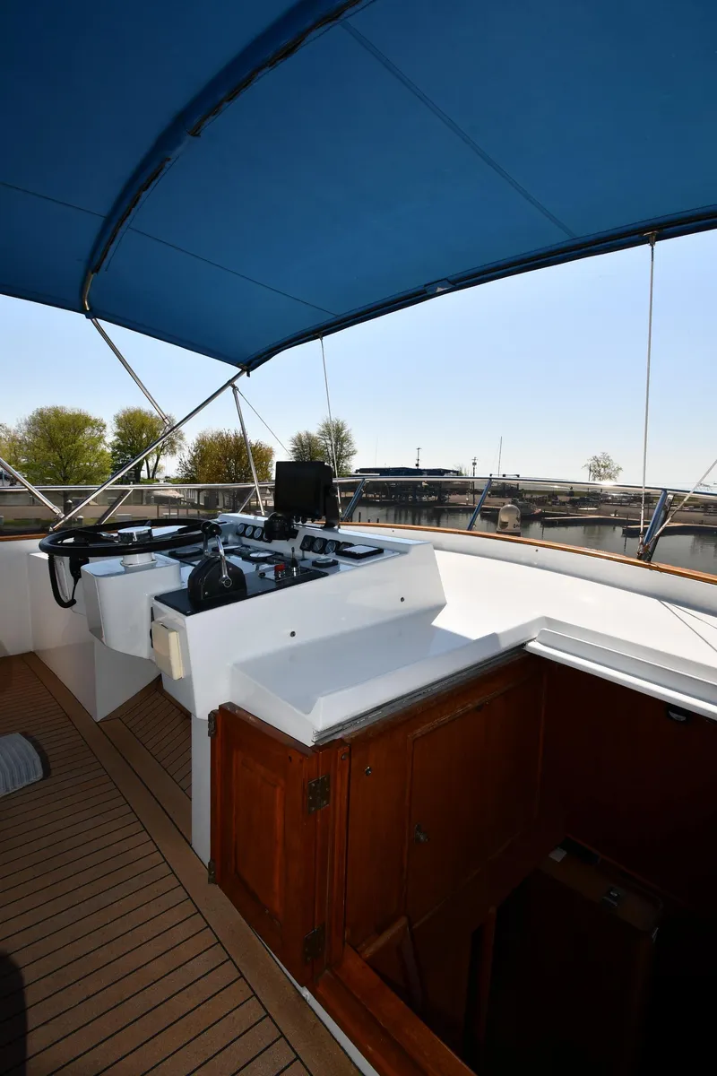 Slide: The Image of 1986 Lowland 64 Pilot House Long Range Motor Yacht helm station with blue canopy. - 32
