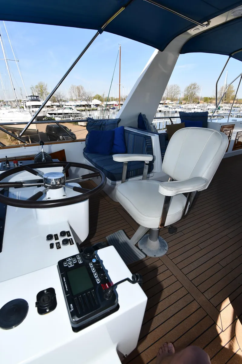 Slide: The Image of 1986 Lowland 64 Pilot House Long Range Motor Yacht helm station with seating and controls. - 34