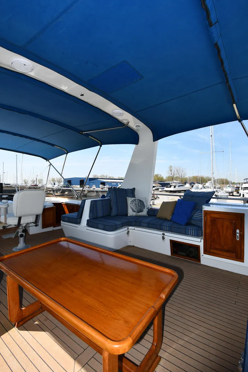Slide: The Image of 1986 Lowland 64 Pilot House Long Range Motor Yacht with spacious deck and blue canopy. - 47