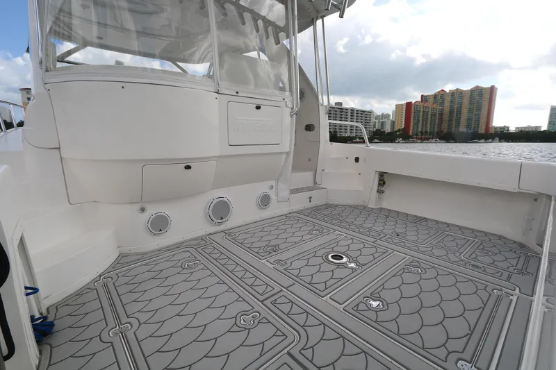 Slide: The Image of 2012 Intrepid 475 Sport Yacht deck with patterned flooring and cityscape background. - 13