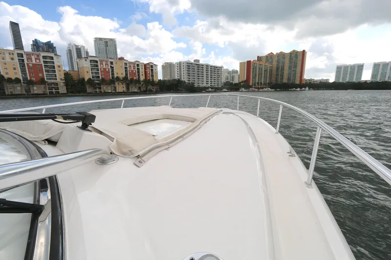 Slide: The Image of 2012 Intrepid 475 Sport Yacht cruising near city skyline on a cloudy day. - 19