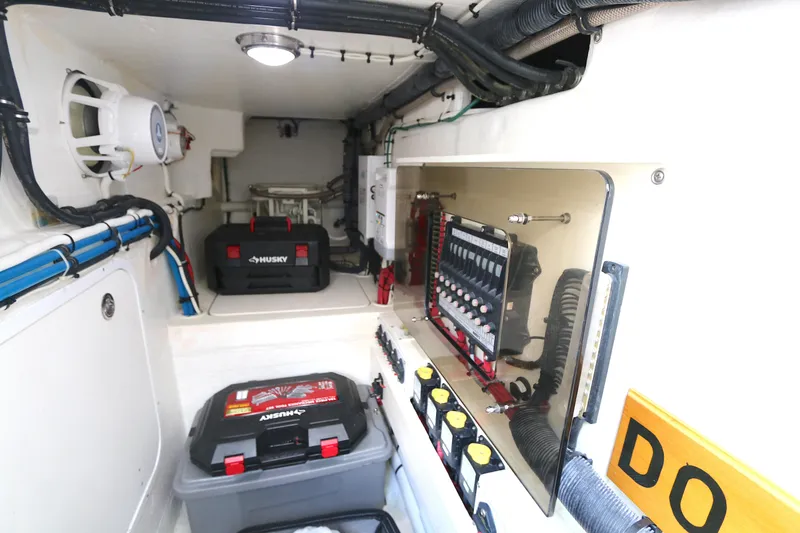 Slide: The Image of 2012 Intrepid 475 Sport Yacht engine room with electrical panel and storage. - 21