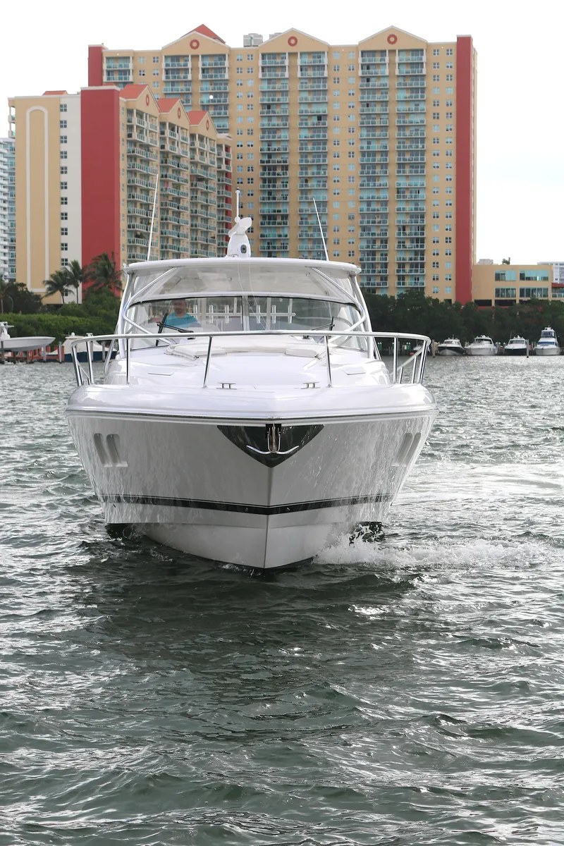 Slide: The Image of 2012 Intrepid 475 Sport Yacht cruising in front of waterfront buildings. - 23