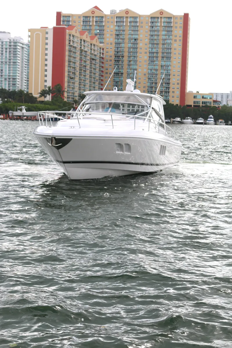 Slide: The Image of 2012 Intrepid 475 Sport Yacht cruising on water with cityscape backdrop. - 24