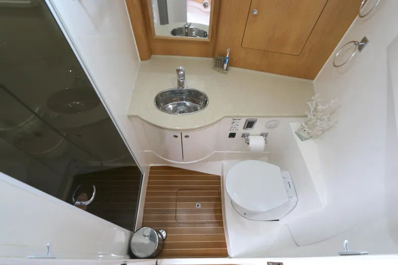 Slide: The Image of Luxurious bathroom in 2012 Intrepid 475 Sport Yacht with modern fixtures and wooden accents. - 5