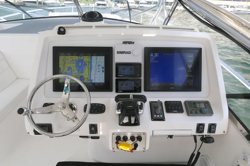 Slide: The Image of Control panel of a 2012 Intrepid 475 Sport Yacht with navigation screens and steering wheel. - 7