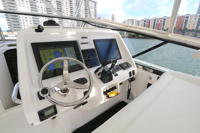 Slide: The Image of Helm of 2012 Intrepid 475 Sport Yacht with navigation screens, steering wheel, and cityscape view. - 8
