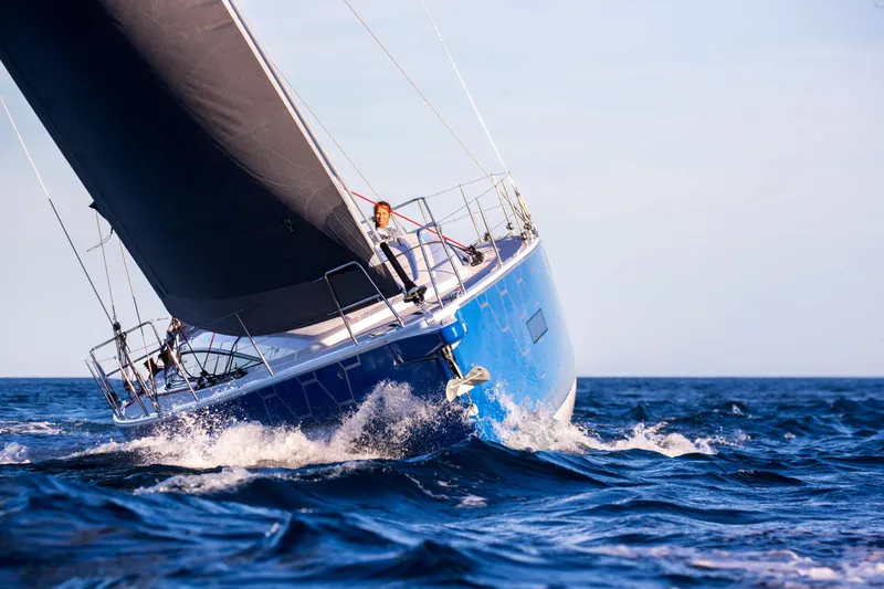 Slide: The Image of 2026 Dehler 46 yacht sailing with crew, vibrant coastal backdrop, dynamic ocean waves. - 49