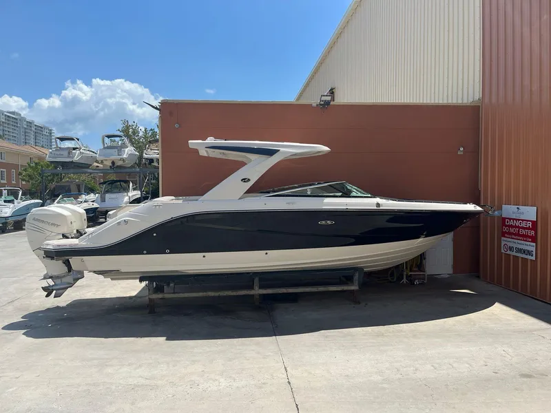 Slide: The Image of 2021 Sea Ray SLX 310 OB boat docked near a warehouse. - 0