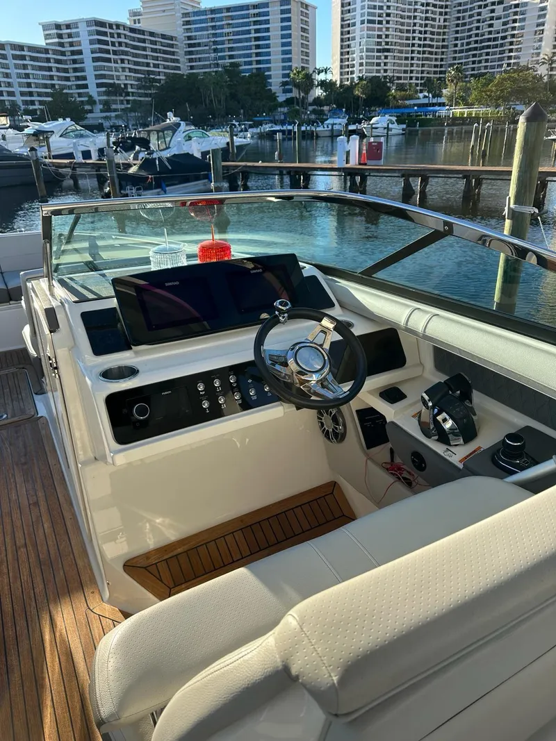 Slide: The Image of 2021 Sea Ray SLX 310 OB boat cockpit with modern controls and waterfront view. - 12