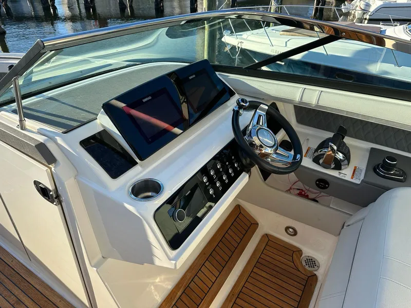 Slide: The Image of 2021 Sea Ray SLX 310 OB boat cockpit with modern controls and wooden flooring. - 15
