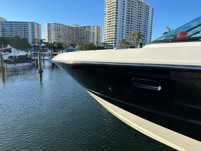 Slide: The Image of 2021 Sea Ray SLX 310 OB docked in a marina with high-rise buildings in the background. - 4