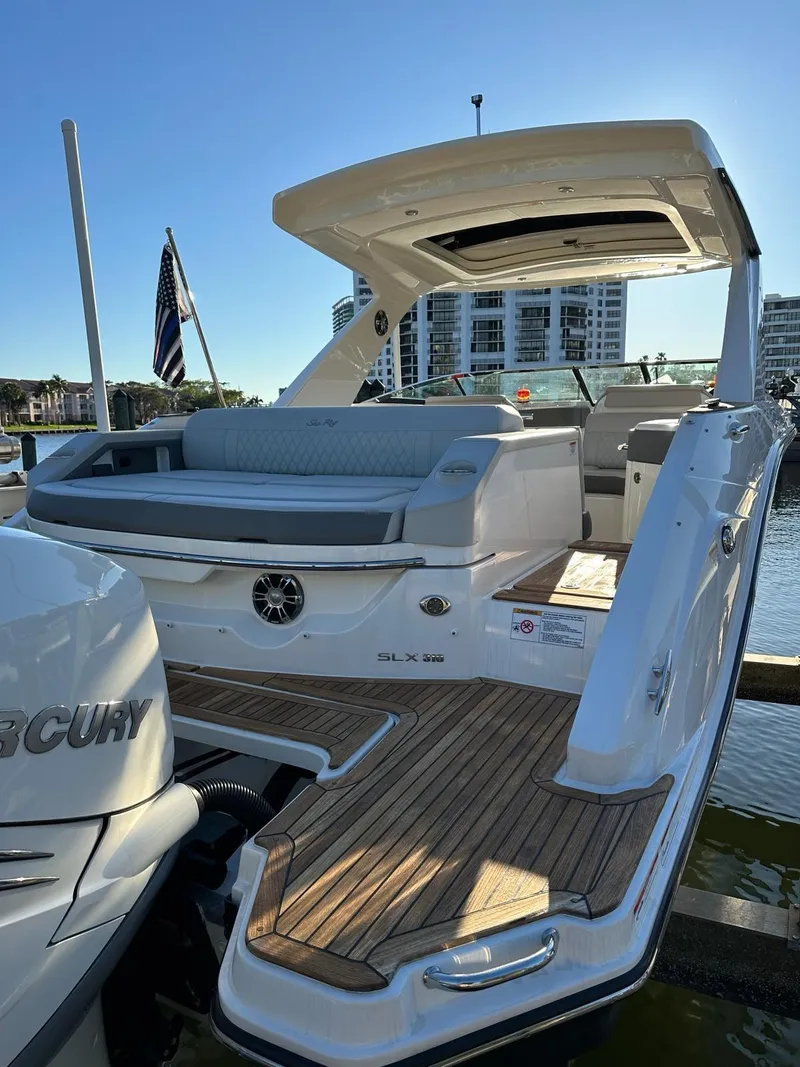 Slide: The Image of 2021 Sea Ray SLX 310 OB luxury motorboat docked with spacious seating. - 8