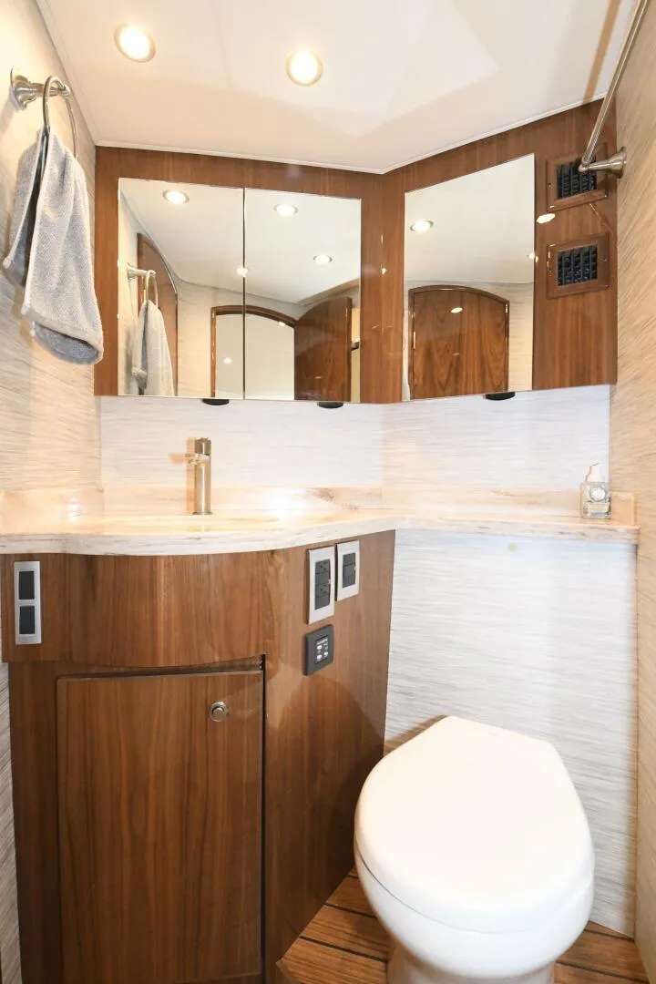 Slide: The Image of 2022 Viking 44 Sport Coupe bathroom with modern fixtures and wood accents. - 18