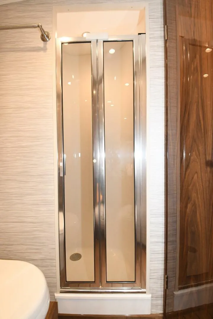 Slide: The Image of Shower area in 2022 Viking 44 Sport Coupe yacht with glass doors. - 19