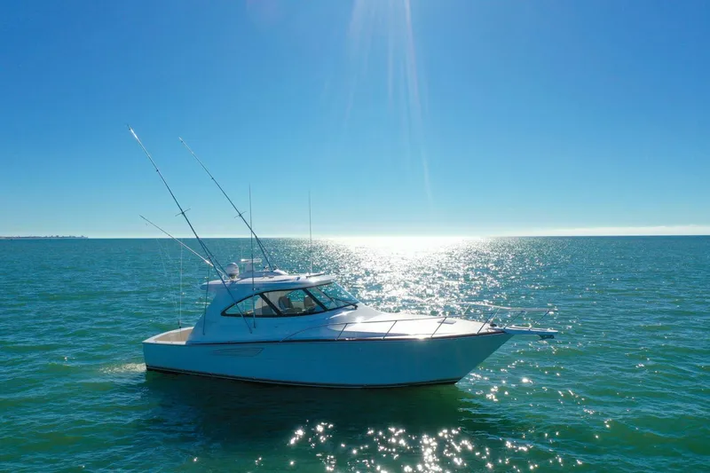 Slide: The Image of 2022 Viking 44 Sport Coupe yacht cruising on sunny ocean waters. - 30