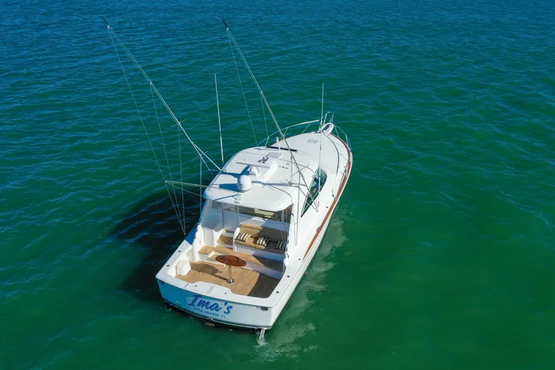 Slide: The Image of 2022 Viking 44 Sport Coupe yacht cruising on clear blue water. - 32