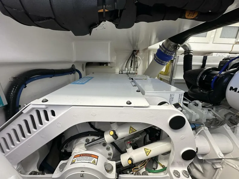Slide: The Image of Engine room of 2022 Viking 44 Sport Coupe, showcasing mechanical components and piping. - 36