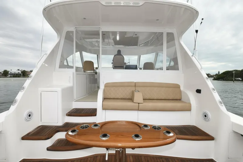 Slide: The Image of 2022 Viking 44 Sport Coupe yacht with elegant seating and wooden table on deck. - 6