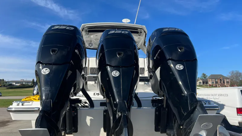 Slide: The Image of 2021 Monterey 385 SE boat with triple outboard engines, parked outdoors. - 41