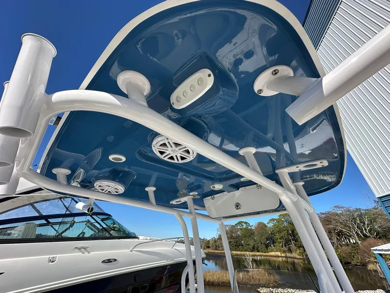 Slide: The Image of 2023 Sportsman Open 212 Center Console boat with blue T-top and rod holders. - 16