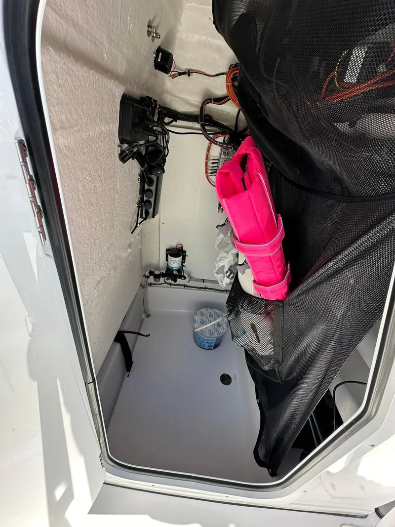 Slide: The Image of 2023 Sportsman Open 212 Center Console storage compartment with equipment and accessories. - 17