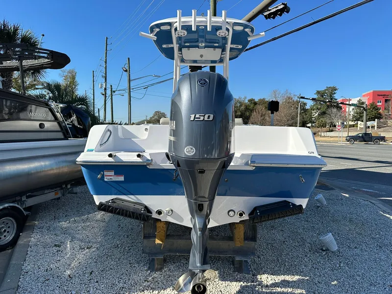 Slide: The Image of 2023 Sportsman Open 212 Center Console boat with 150 HP engine, displayed outdoors. - 2