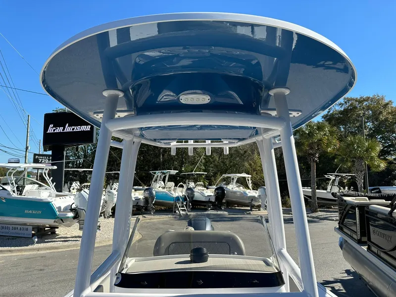 Slide: The Image of 2023 Sportsman Open 212 Center Console boat with T-top, displayed outdoors. - 20
