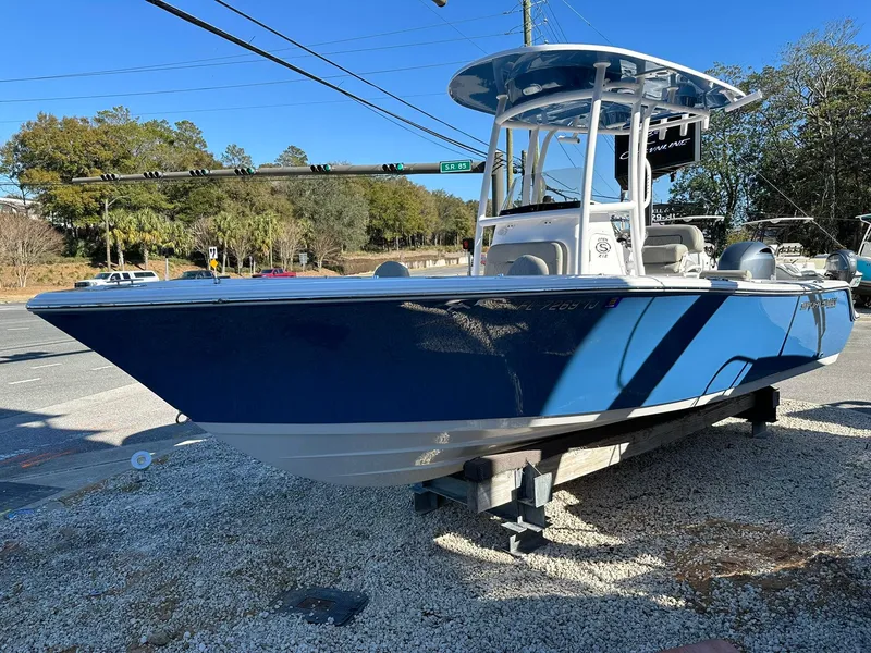 Slide: The Image of 2023 Sportsman Open 212 Center Console boat displayed outdoors on gravel. - 4