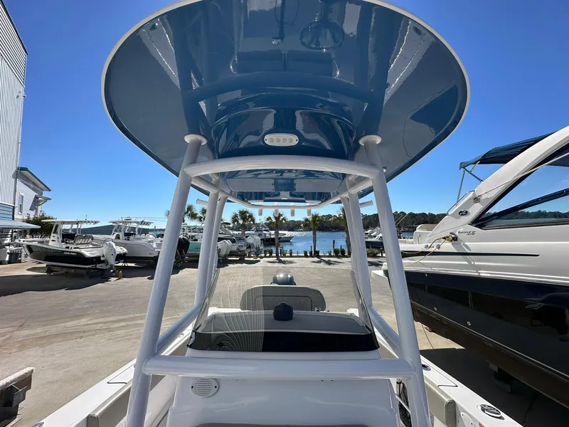 Slide: The Image of 2023 Sportsman Open 212 Center Console boat at marina, clear sky, waterfront view. - 9