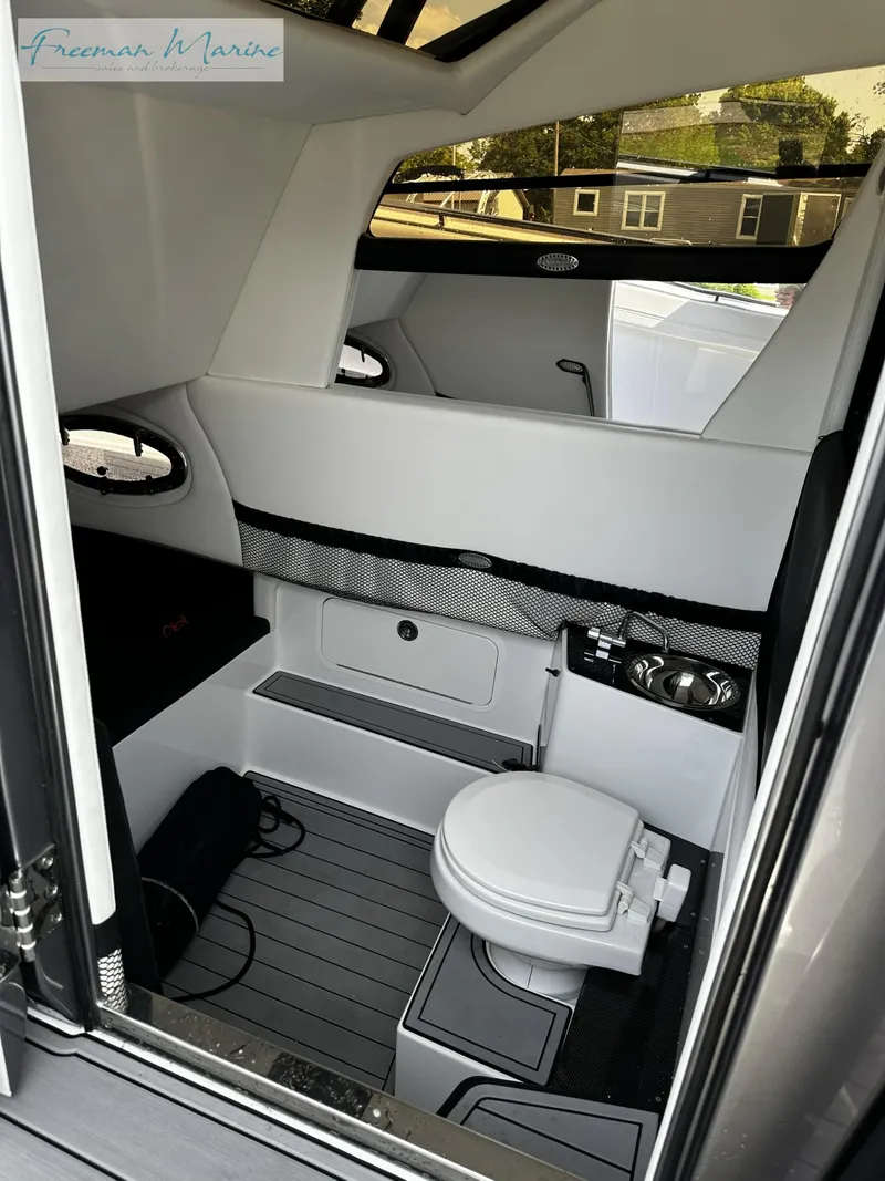 Slide: The Image of 2022 Nor-Tech 390 Center Console interior cabin with toilet and sink. - 14