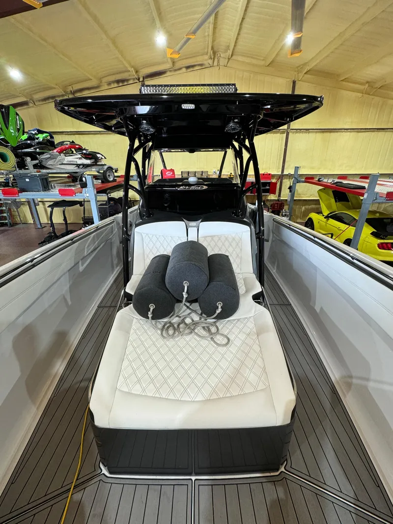 Slide: The Image of 2022 Nor-Tech 390 Center Console boat with white seating and black cushions in a showroom. - 17
