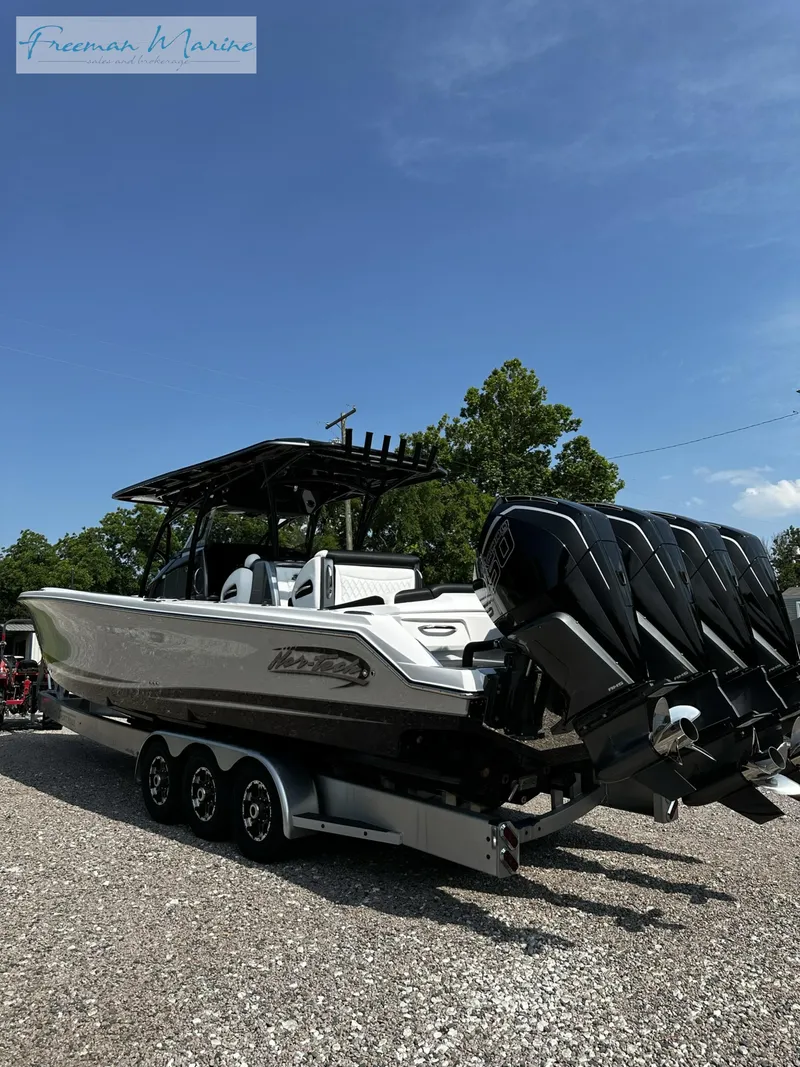 Slide: The Image of 2022 Nor-Tech 390 Center Console boat with triple outboard engines on a trailer. - 2
