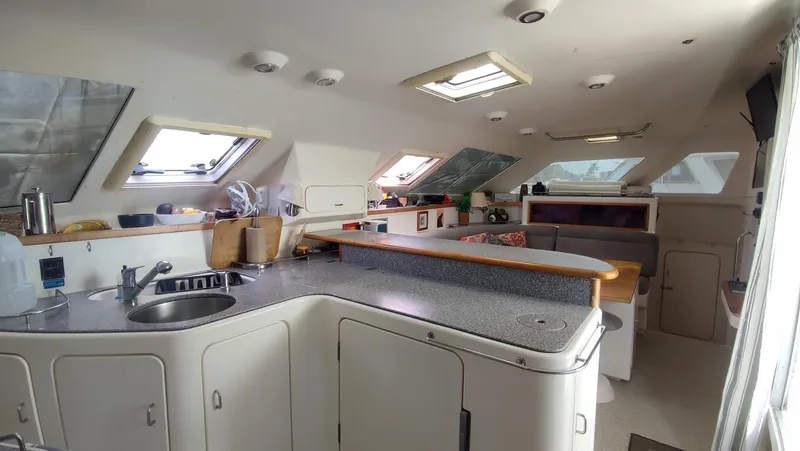 Slide: The Image of Interior of 2002 Voyage 440 catamaran with modern kitchen and seating area. - 16