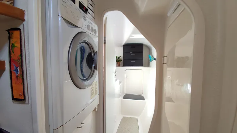 Slide: The Image of Laundry area inside a 2002 Voyage 440 yacht, featuring a washer and dryer. - 20