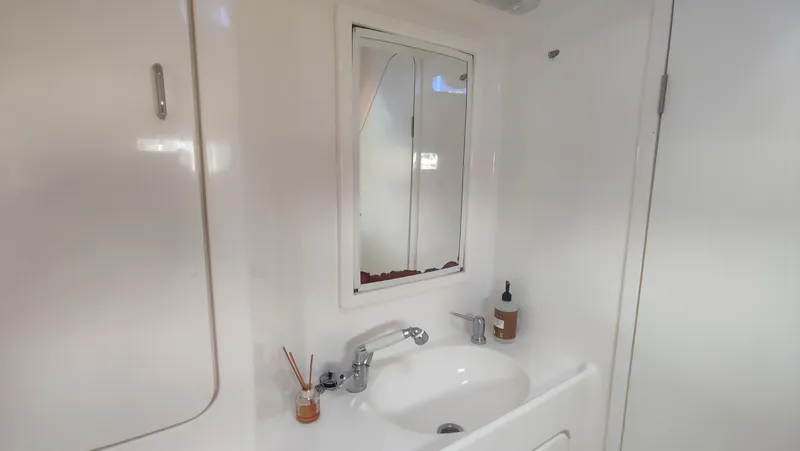Slide: The Image of Bathroom sink area in 2002 Voyage 440 yacht, featuring a mirror and toiletries. - 26