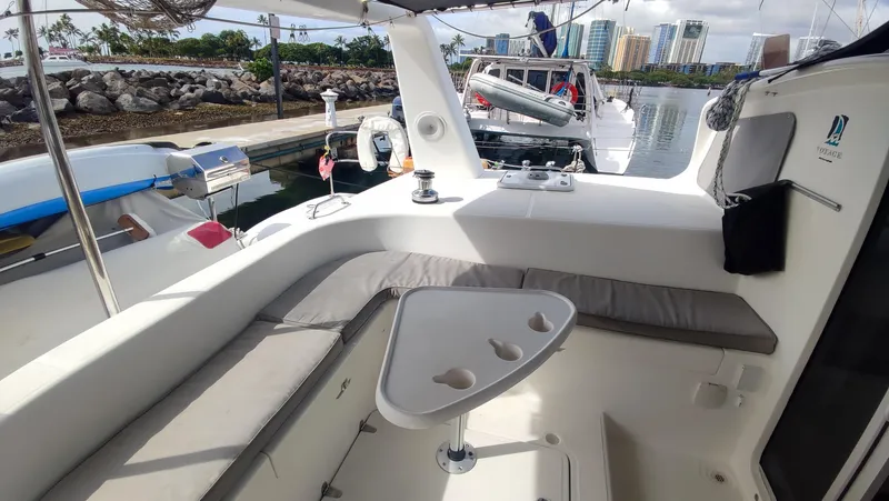 Slide: The Image of 2002 Voyage 440 yacht cockpit with seating and table, docked in a marina. - 6