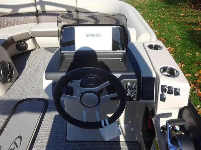Slide: The Image of 2024 Harris Sunliner 230 Sport boat dashboard with steering wheel and Simrad display. - 13