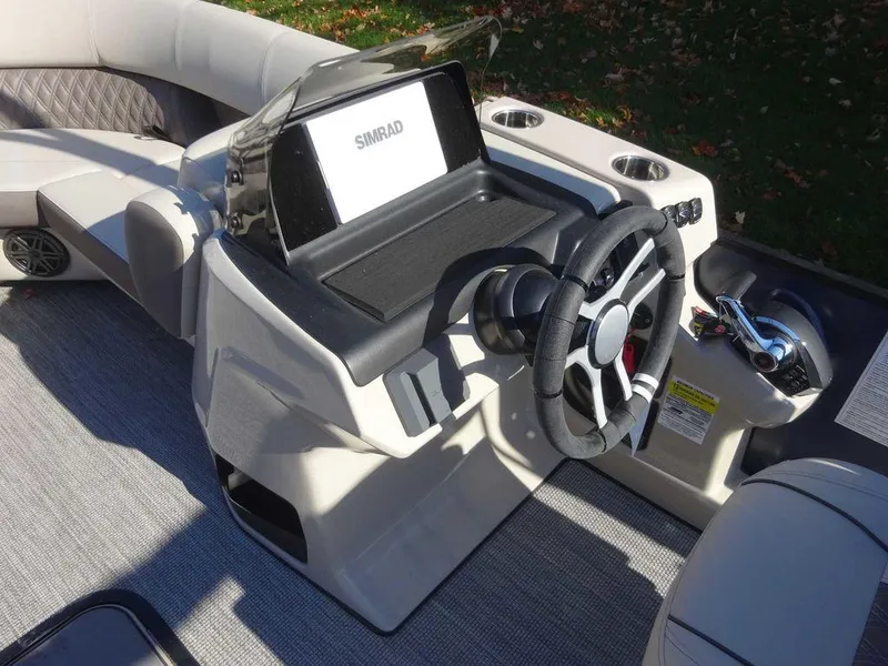 Slide: The Image of 2024 Harris Sunliner 230 Sport boat dashboard with steering wheel and Simrad display. - 14