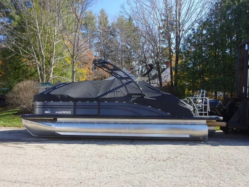 Slide: The Image of 2024 Harris Sunliner 230 Sport pontoon boat, covered and parked outdoors. - 3