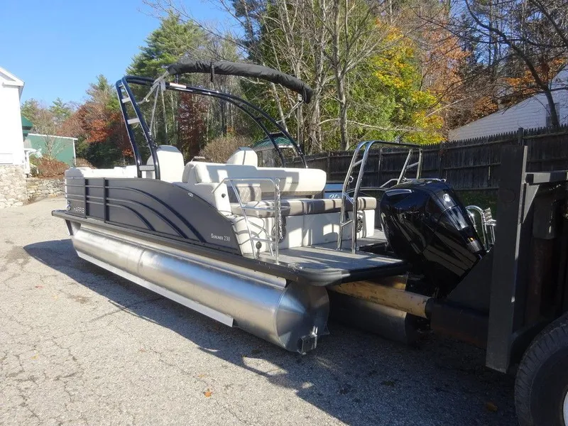 Slide: The Image of 2024 Harris Sunliner 230 Sport pontoon boat on trailer, parked outdoors. - 4