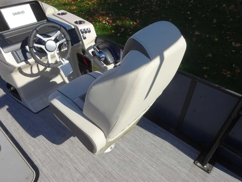 Slide: The Image of 2024 Harris Sunliner 230 Sport boat interior with steering wheel and captain's chair. - 9